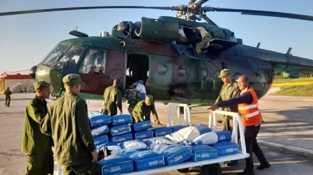 Militares subiendo alimentos a un helicóptero. (Foto © Minfar Cuba-Facebook)